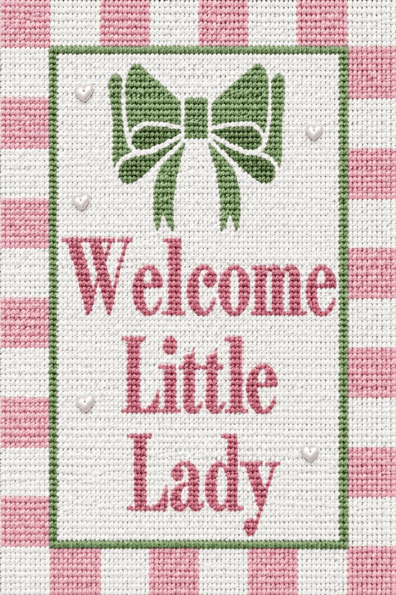 “Stitched Little Lady needlepoint with a green bow, pink checked border, white hearts and ‘Welcome Little Lady’ lettering.”